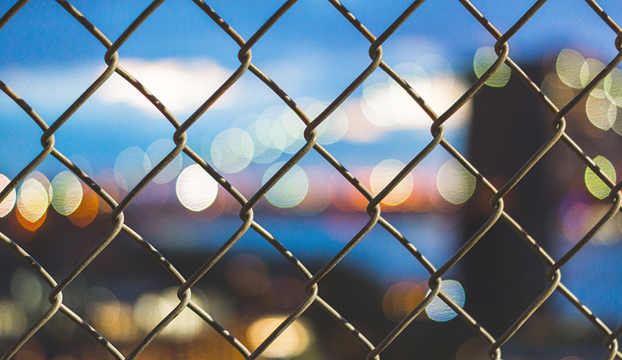 A chain link fence in front of a blurry background