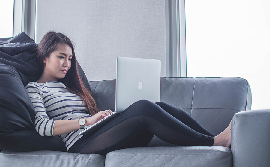 Woman Using Laptop on Couch