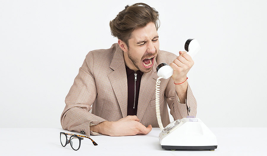 Professional looking man yelling into phone