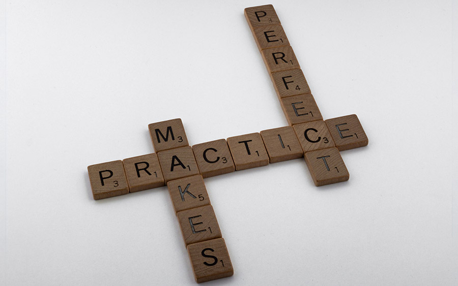 Scrabble tiles that spell out practice makes perfect